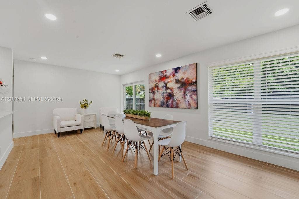 800 Alamanda Drive, North Palm Beach, North Palm Beach, FL 33408 Neutral-toned interior featuring wood-finish tile flooring, recessed lighting, and large windows with horizontal blinds
