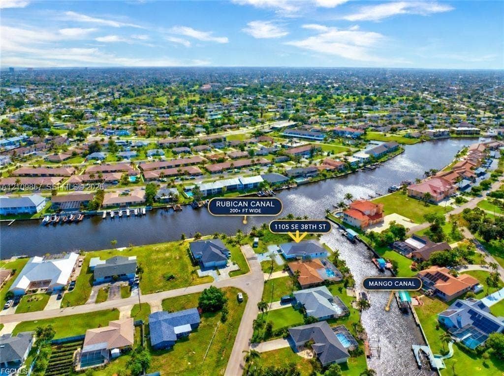 1105 SE 38th Street, Cape Coral, FL 33904 Aerial perspective featuring a waterfront property situated at the confluence of the Rubican Canal and Mango Canal