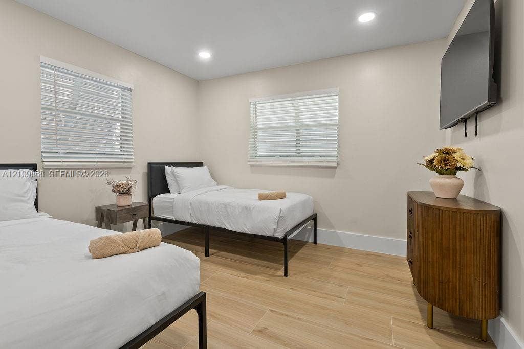 736 Prosperity Farms Road, North Palm Beach, North Palm Beach, FL 33408 Interior room featuring wood-finish flooring, neutral walls, two horizontal windows with slatted blinds, and recessed lighting