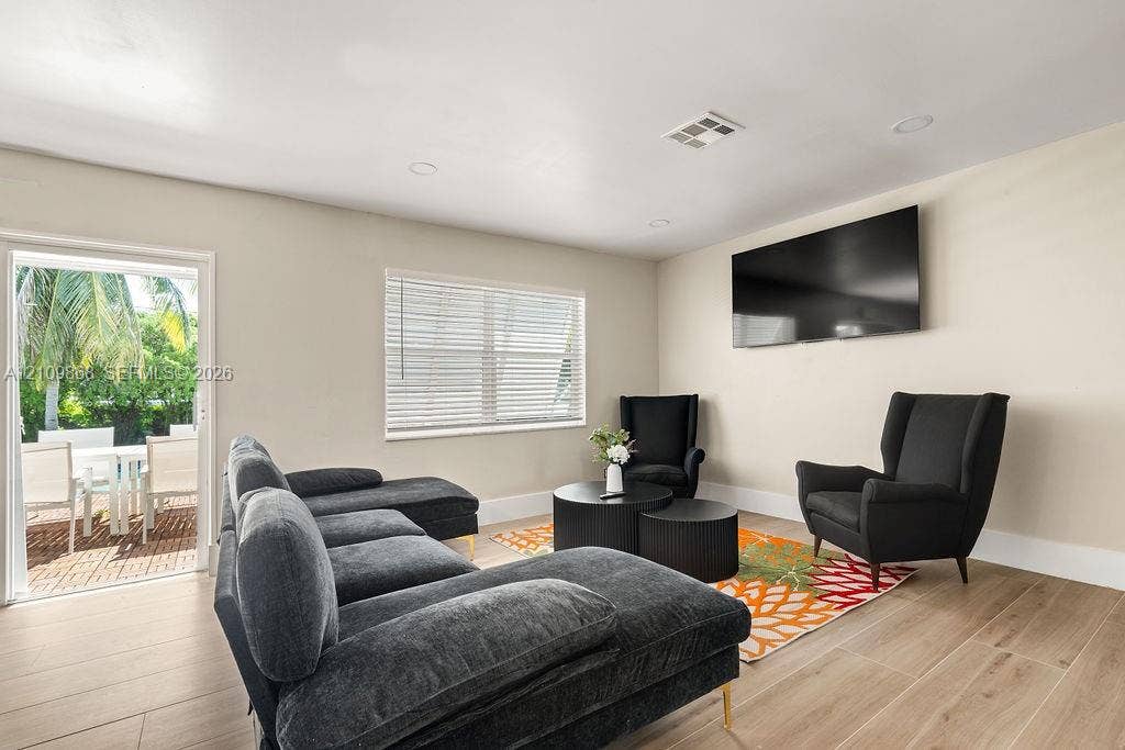 736 Prosperity Farms Road, North Palm Beach, North Palm Beach, FL 33408 Neutral-toned interior featuring wood-finish flooring, recessed lighting, and a glass-paned door providing outdoor access