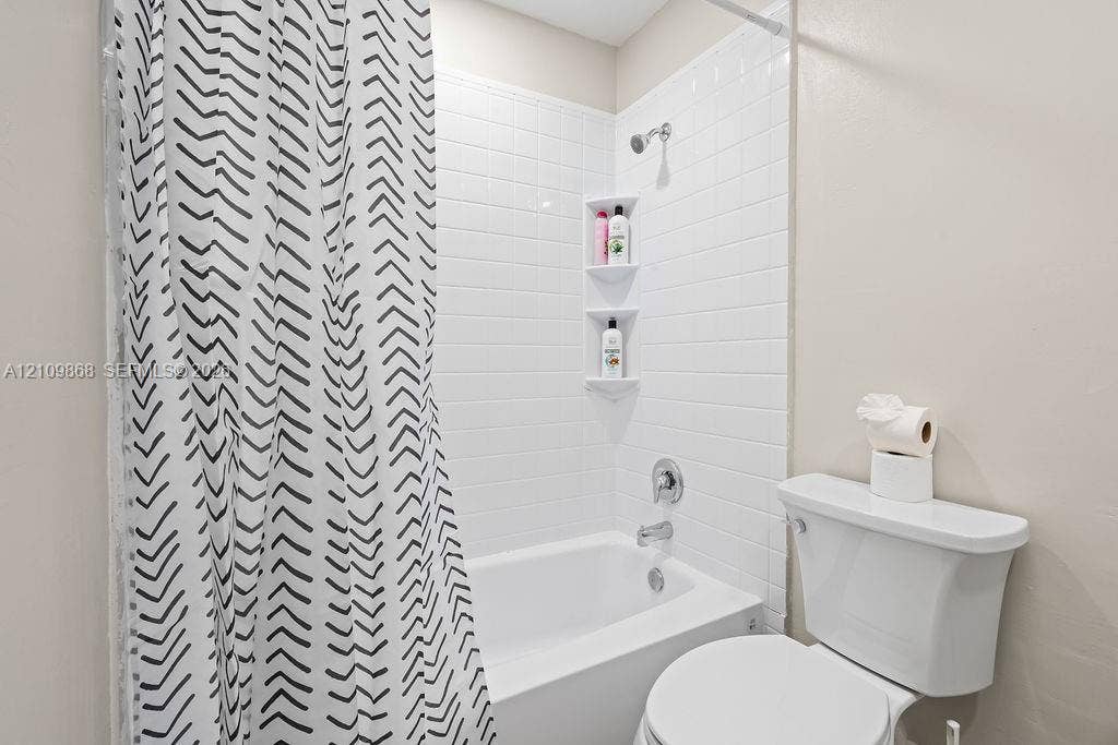 736 Prosperity Farms Road, North Palm Beach, North Palm Beach, FL 33408 Bathtub with white subway tile surround, integrated dual shelving niches, and chrome fixtures