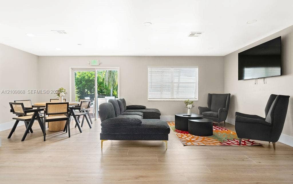 736 Prosperity Farms Road, North Palm Beach, North Palm Beach, FL 33408 Open-concept interior featuring wood-finish tile flooring, neutral wall paint, recessed lighting, and a sliding glass door providing exterior exposure