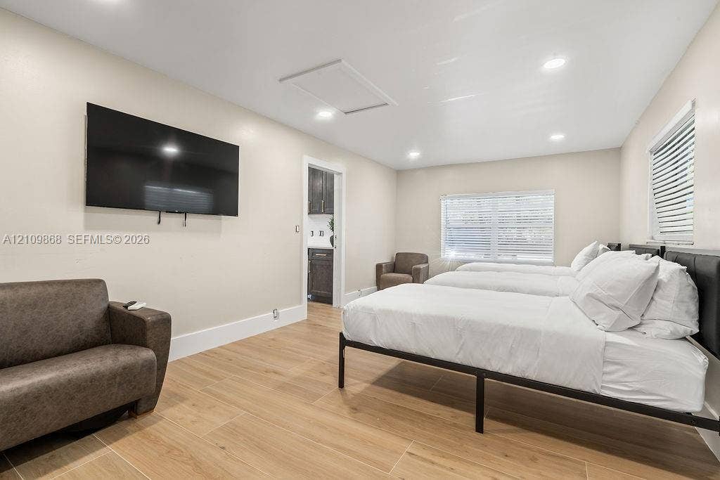 736 Prosperity Farms Road, North Palm Beach, North Palm Beach, FL 33408 Neutral-toned interior featuring wood-finish flooring, recessed lighting, and windows equipped with horizontal blinds