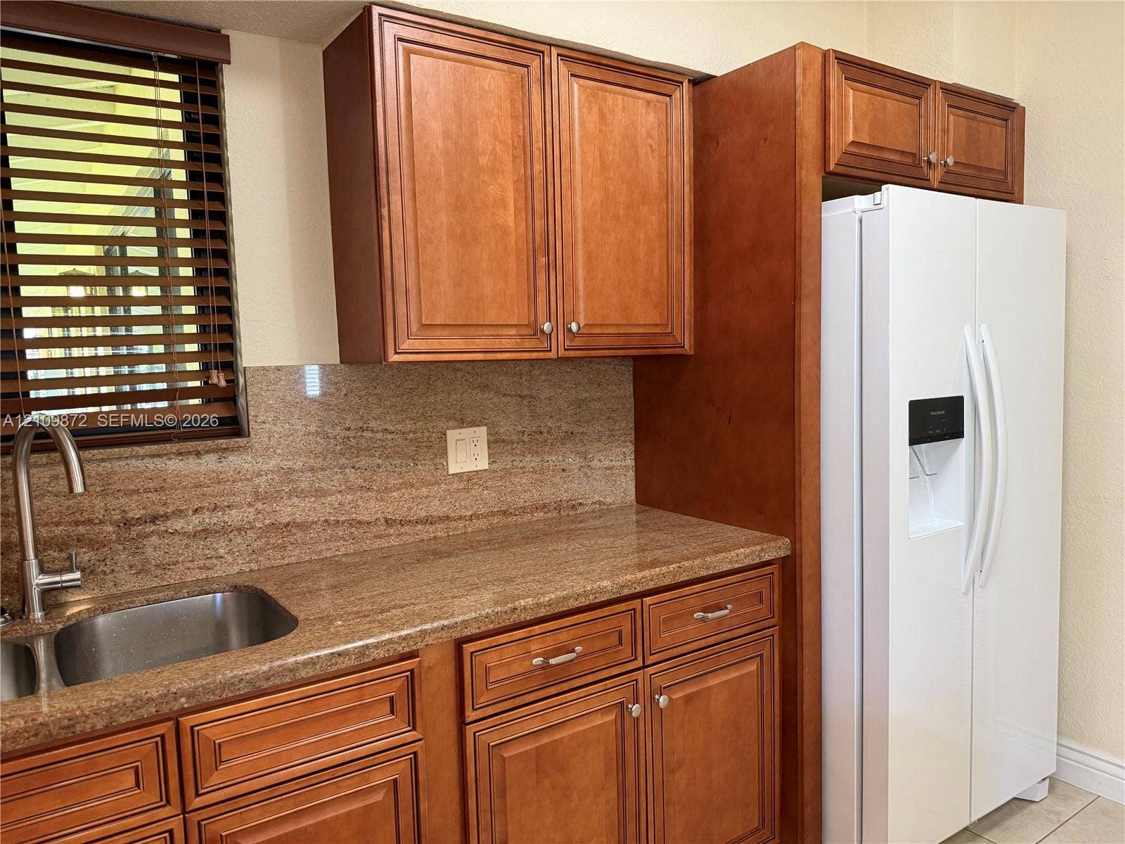 811 NE 10th Street, #5, Hallandale Beach, Hallandale Beach, FL 33009 Kitchen featuring natural-finish wood cabinetry, stone-surface countertops, matching stone backsplash, stainless steel under-mount sink, and gooseneck faucet