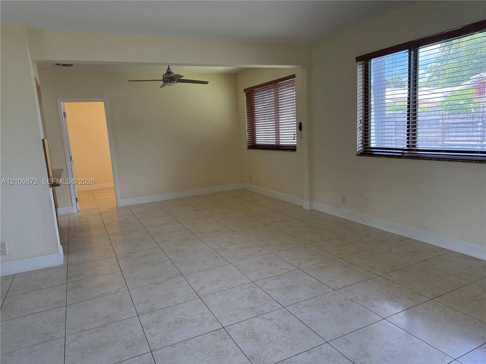 811 NE 10th Street, #5, Hallandale Beach, Hallandale Beach, FL 33009 Interior space featuring neutral tile flooring, multiple windows with horizontal blinds, and a ceiling fan