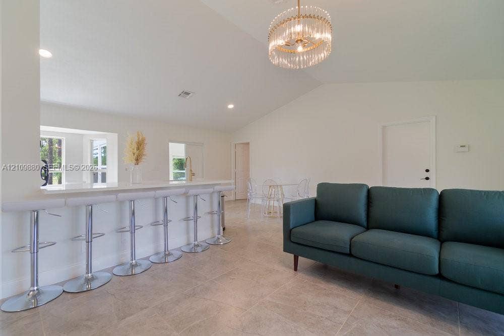 8231 Coconut Boulevard, West Palm Beach, West Palm Beach, FL 33412 Vaulted ceilings, large-format tile flooring, quartz breakfast bar, and tiered crystal chandelier