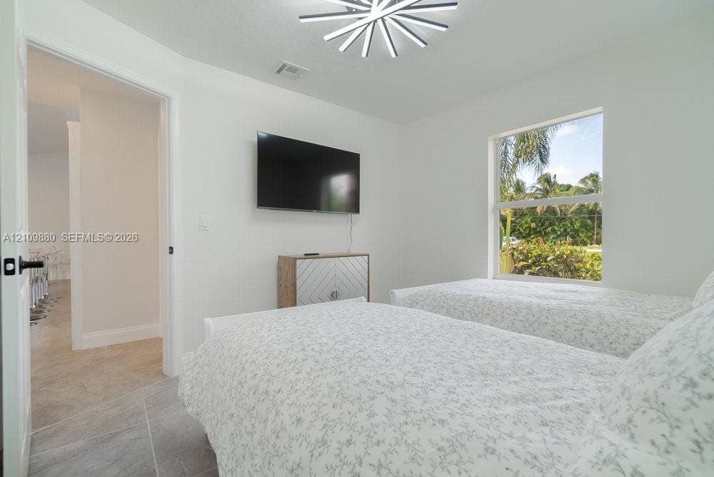 8231 Coconut Boulevard, West Palm Beach, West Palm Beach, FL 33412 Neutral interior featuring large-format tile flooring, a geometric multi-point chandelier, and a single-pane window
