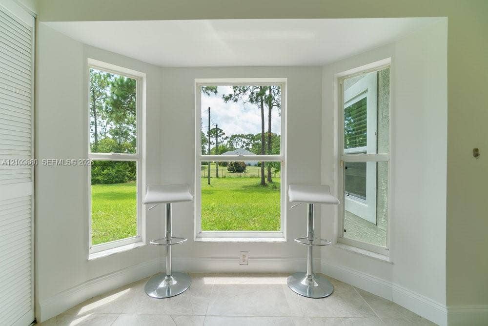 8231 Coconut Boulevard, West Palm Beach, West Palm Beach, FL 33412 Bay window with triple-pane windows, neutral stone-finish tile flooring, and white louvered closet doors