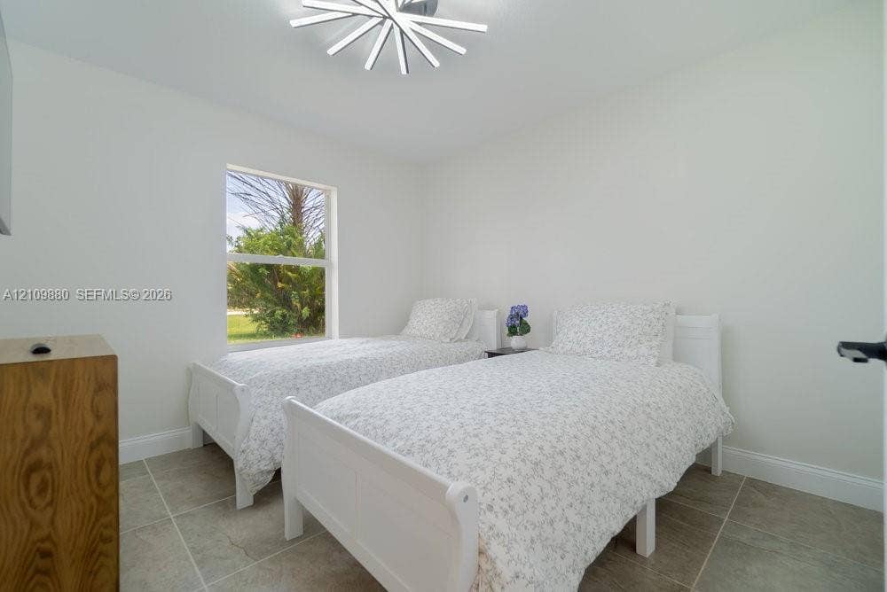 8231 Coconut Boulevard, West Palm Beach, West Palm Beach, FL 33412 Neutral-toned room featuring large-format ceramic tile flooring, a geometric LED ceiling fixture, and a single-pane window
