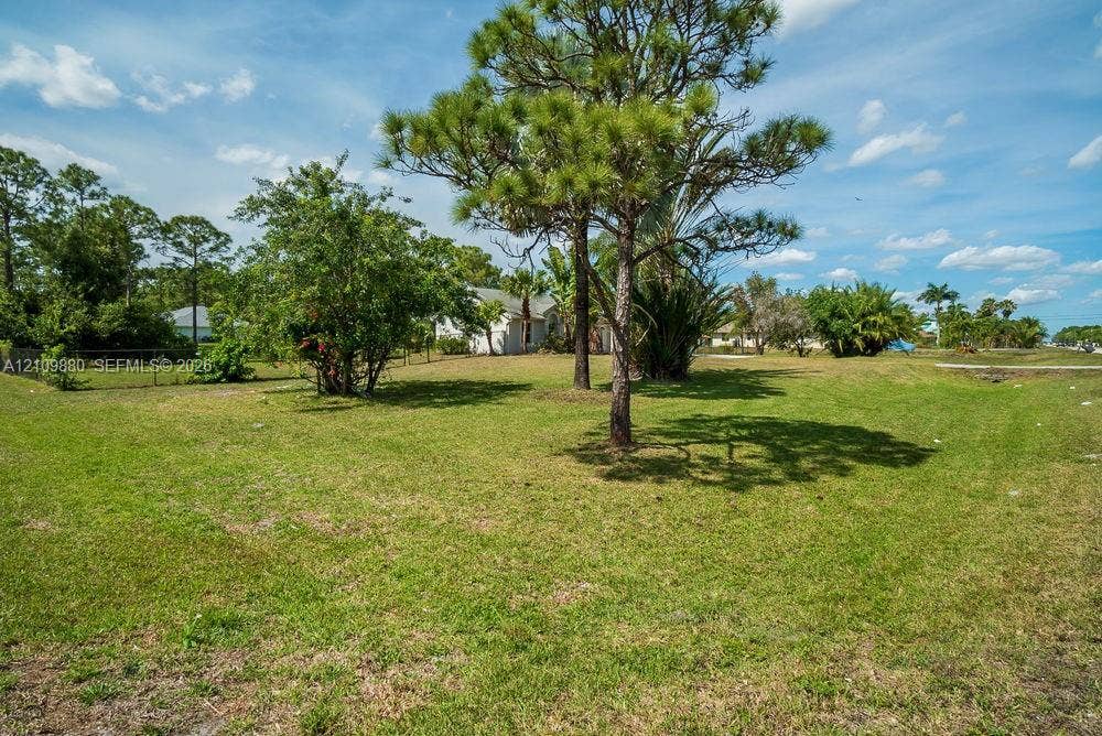 8231 Coconut Boulevard, West Palm Beach, West Palm Beach, FL 33412 Expansive lot featuring mature pine trees, established tropical foliage, and grass lawn