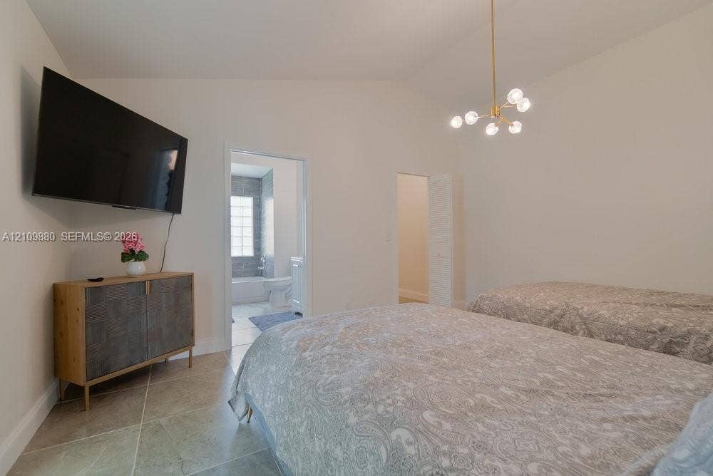 8231 Coconut Boulevard, West Palm Beach, West Palm Beach, FL 33412 Vaulted ceilings, large-format tile flooring, and a contemporary multi-arm brass chandelier