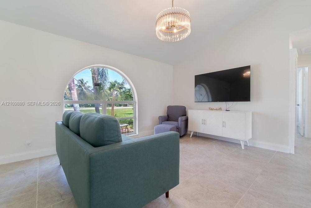 8231 Coconut Boulevard, West Palm Beach, West Palm Beach, FL 33412 Arched window with exterior scenery, neutral tile flooring, and decorative multi-tier drum chandelier