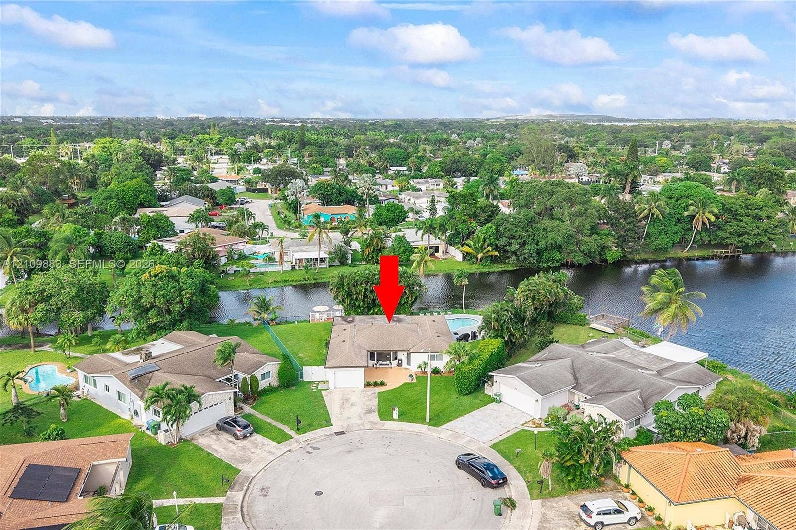 751 SW 54th Avenue, Margate, FL 33068 Waterfront residence featuring a shingle roof, paved driveway, two-car garage, and a rear swimming pool situated on a cul-de-sac