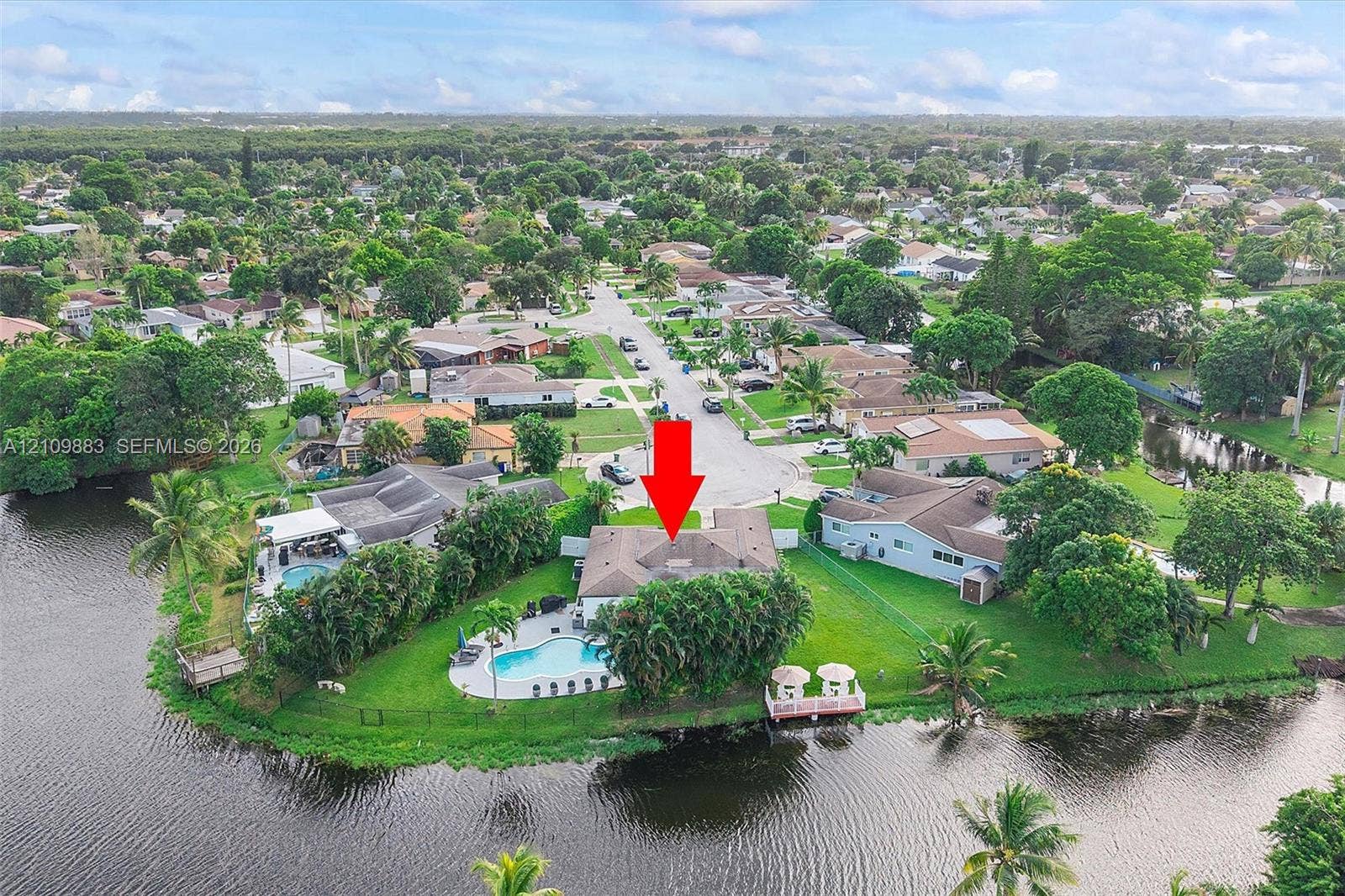 751 SW 54th Avenue, Margate, FL 33068 Waterfront property featuring a private swimming pool, concrete patio, dock, and extensive perimeter landscaping