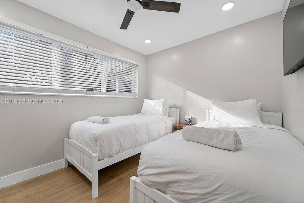 712 Tradewind Drive, North Palm Beach, North Palm Beach, FL 33408 Neutral-toned interior featuring wood-finish flooring, a ceiling fan with integrated lighting, recessed lighting, and horizontal window blinds
