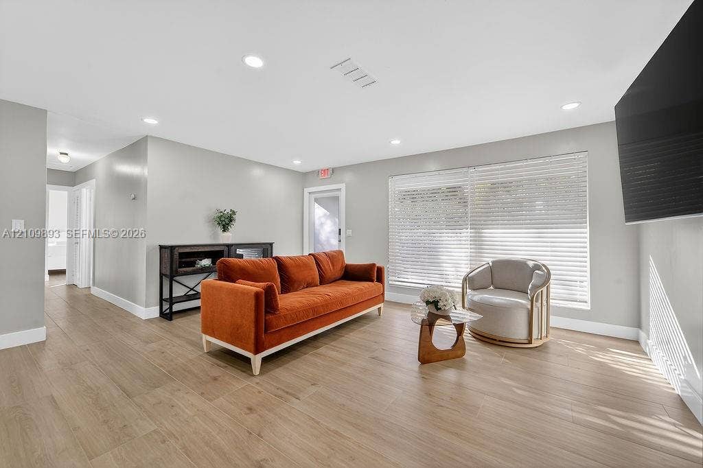 712 Tradewind Drive, North Palm Beach, North Palm Beach, FL 33408 Interior living space featuring wood-finish flooring, recessed lighting, and large windows with horizontal blinds