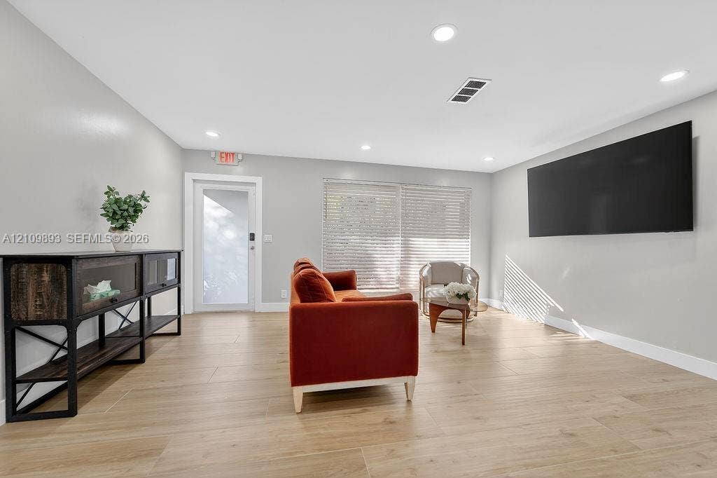 712 Tradewind Drive, North Palm Beach, North Palm Beach, FL 33408 Spacious interior featuring neutral wall tones, recessed lighting, wood-finish tile flooring, and a glass-paneled exterior door