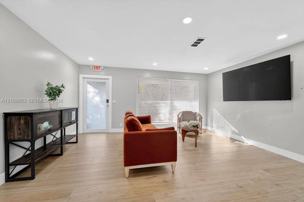 712 Tradewind Drive, North Palm Beach, North Palm Beach, FL 33408 Neutral-toned interior featuring wood-finish flooring, recessed lighting, and a single-pane glass door with white trim