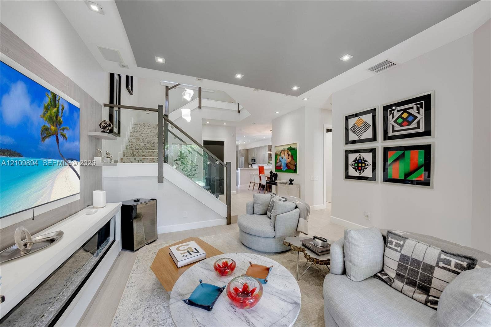 Interior space featuring recessed lighting, a built-in media console with linear fireplace, and a staircase with glass panel railing and dark finish handrail