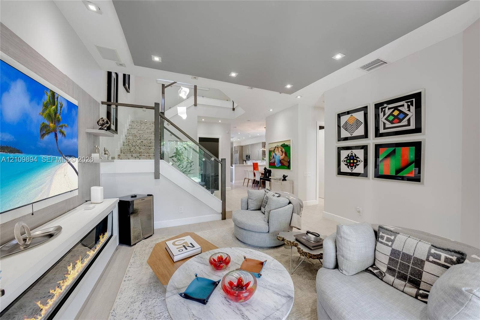 Linear electric fireplace with built-in surround shelving, glass-panel staircase railing, recessed lighting, and neutral flooring