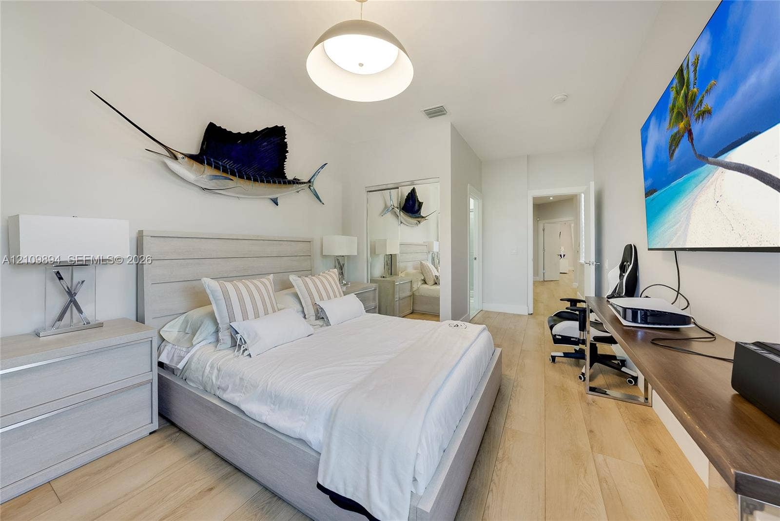 Room featuring wood-finish flooring, recessed lighting, a modern pendant light fixture, and floor-to-ceiling mirrored closet doors