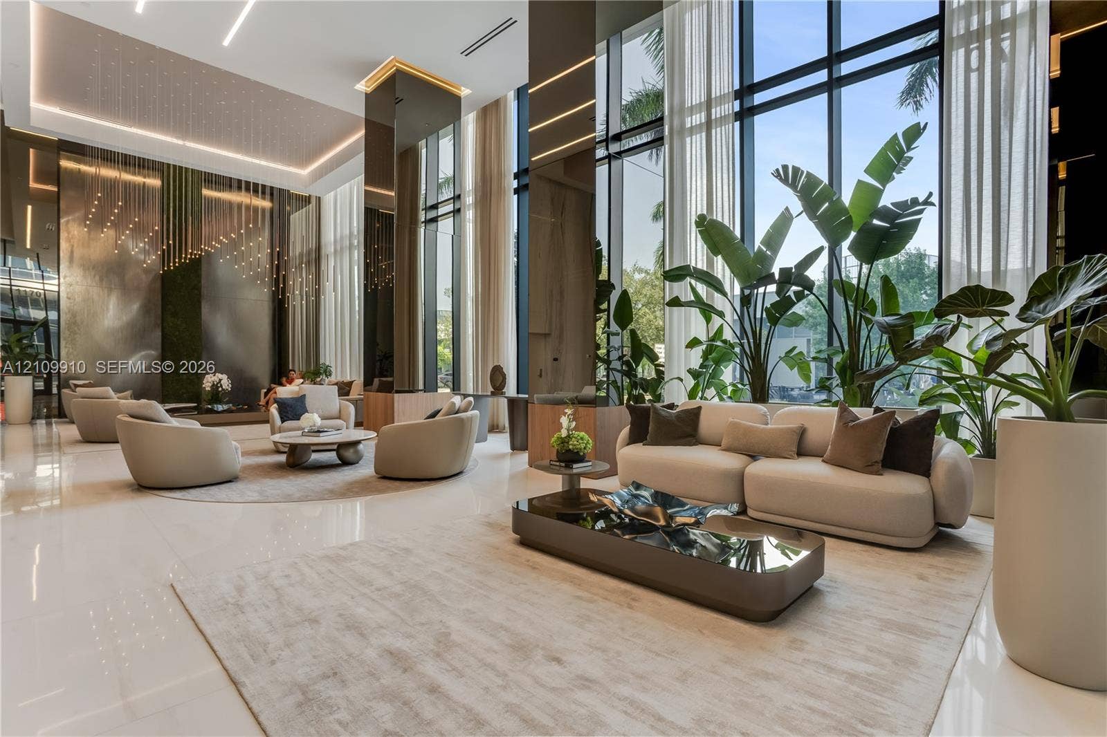 1170 E Hallandale Beach Boulevard, #908, Hallandale Beach, FL 33009 Double-height floor-to-ceiling windows, polished stone flooring, recessed ceiling lighting, reflective wall paneling, and architectural metallic accent features
