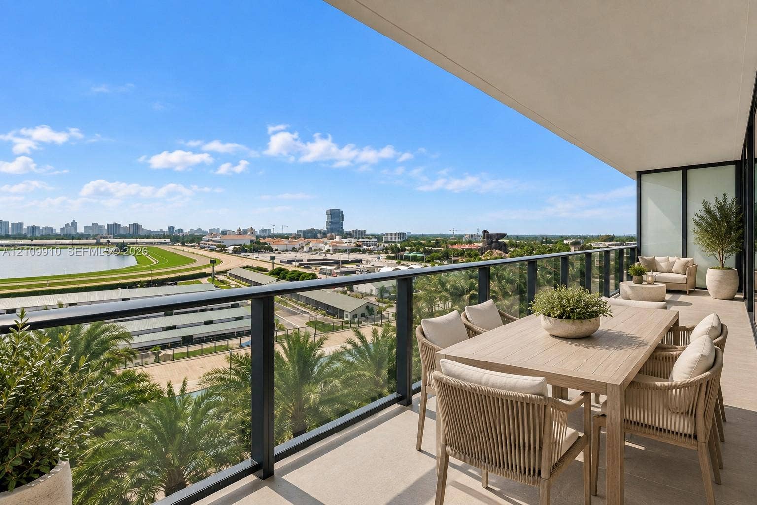 1170 E Hallandale Beach Boulevard, #908, Hallandale Beach, FL 33009 Covered balcony featuring neutral tile flooring, a sleek black metal railing with glass panels, and an expansive cityscape horizon
