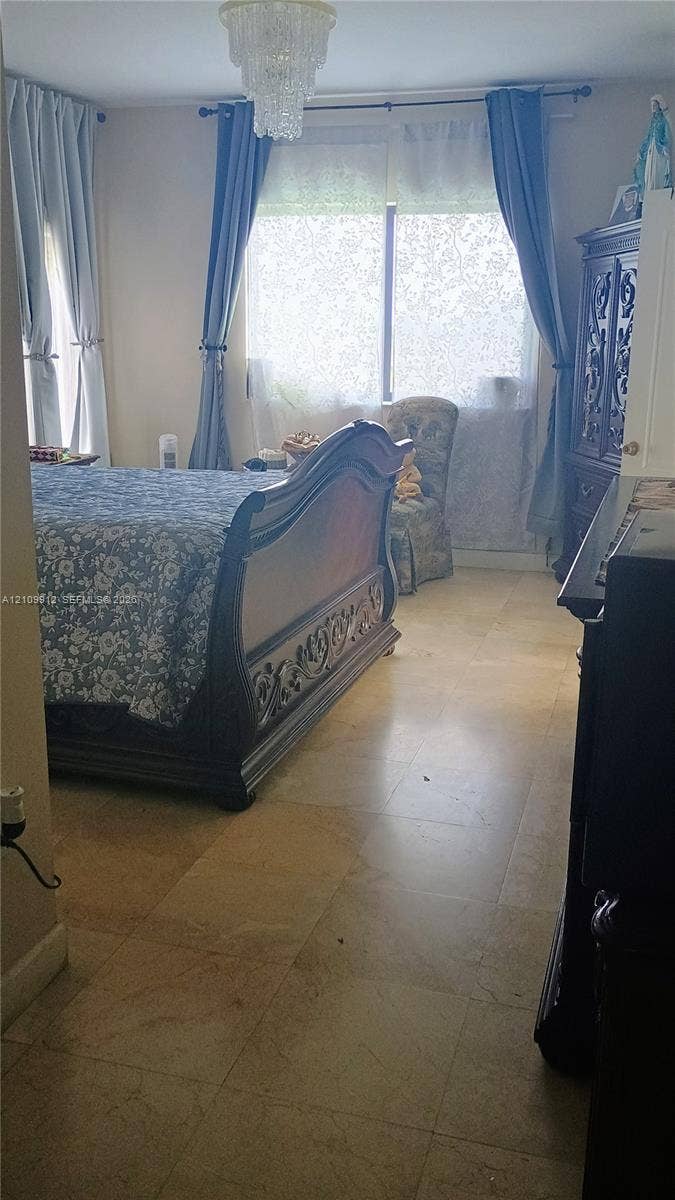 3253 SW 150 Court, Miami, FL 33185 Large-format stone tile flooring, multi-panel windows, and a tiered crystal chandelier fixture