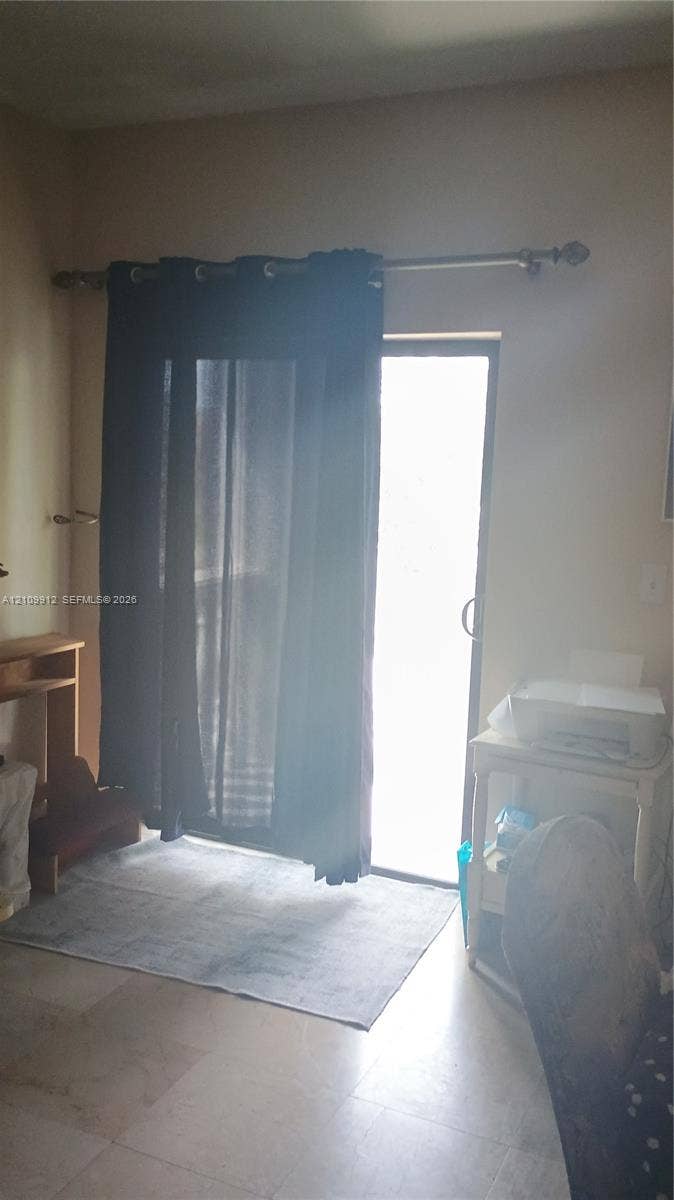 3253 SW 150 Court, Miami, FL 33185 Sliding glass door with a metal curtain rod and neutral stone-finish flooring
