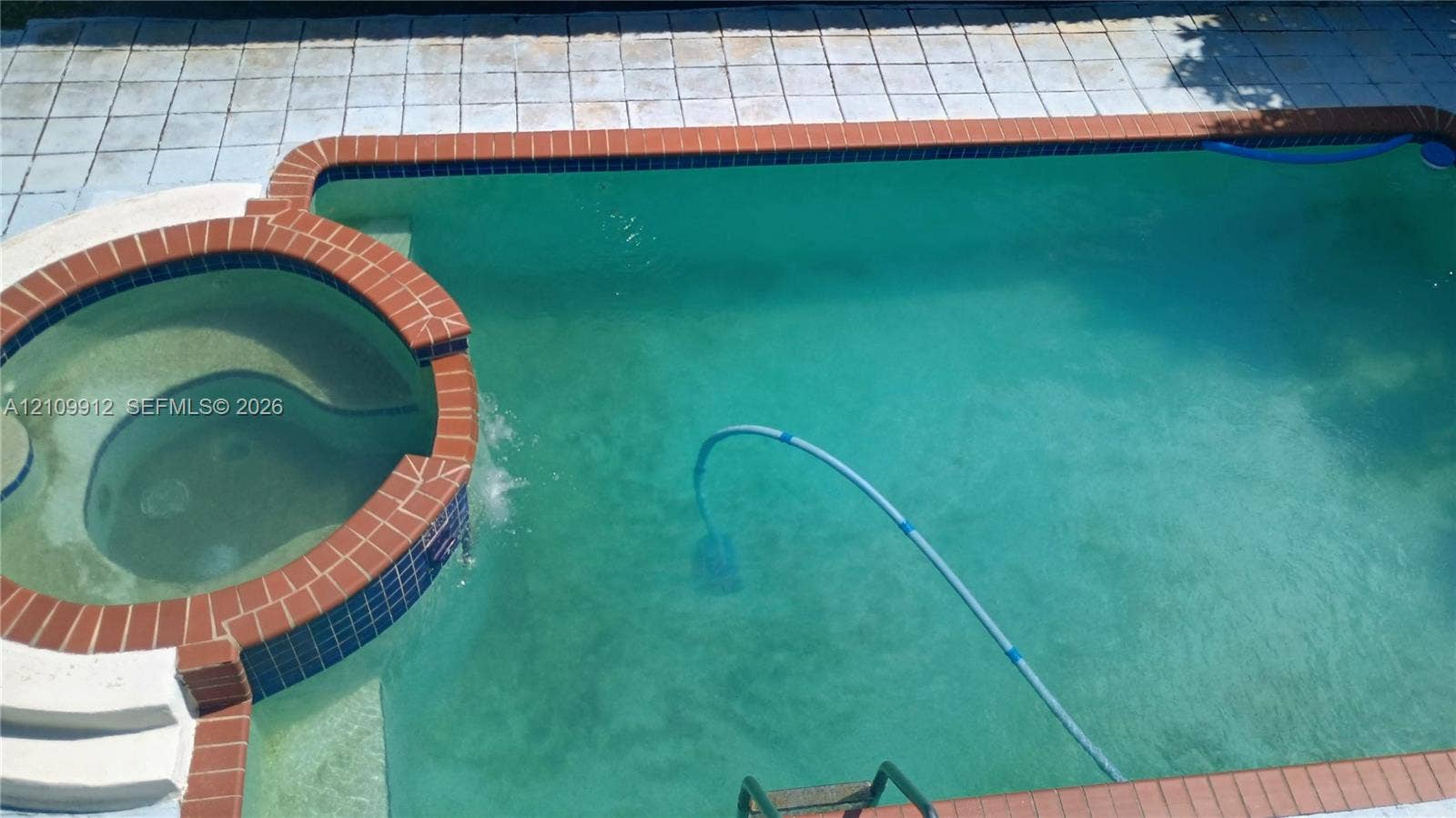 3253 SW 150 Court, Miami, FL 33185 In-ground swimming pool with an integrated circular spa, brick coping, and light-toned patio hardscaping