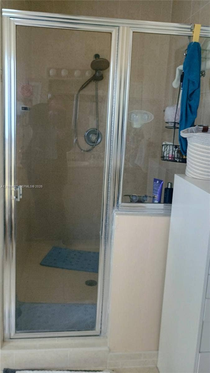 3253 SW 150 Court, Miami, FL 33185 Shower enclosure featuring a chrome-framed glass door, wall-mounted showerhead, and tile surround