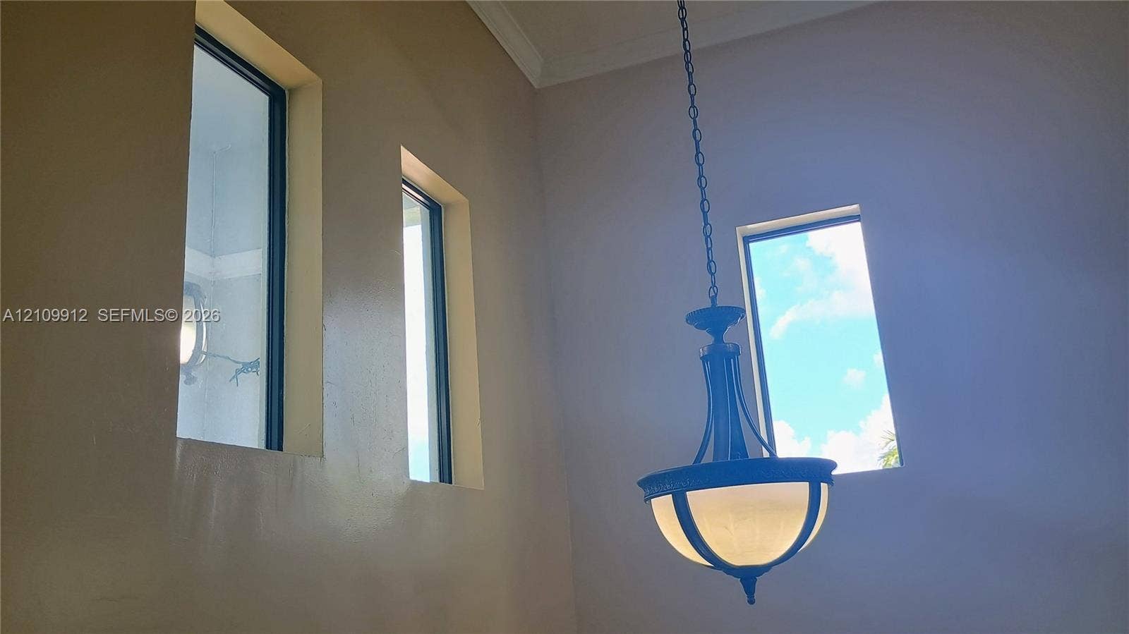 3253 SW 150 Court, Miami, FL 33185 High-ceiling space featuring multiple tall rectangular windows and a tiered metal pendant light fixture with frosted glass shades