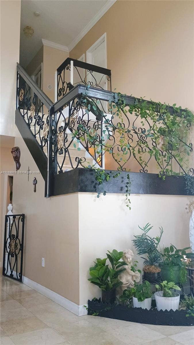 3253 SW 150 Court, Miami, FL 33185 Staircase featuring decorative wrought-iron railings, high ceilings, and stone-finish tile flooring