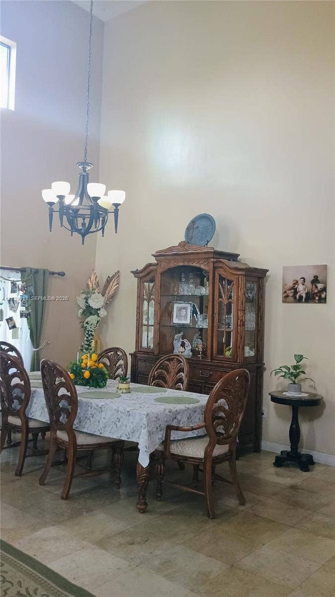 3253 SW 150 Court, Miami, FL 33185 High-vaulted ceiling, neutral wall palette, stone-finish tile flooring, and multi-light chandelier fixture