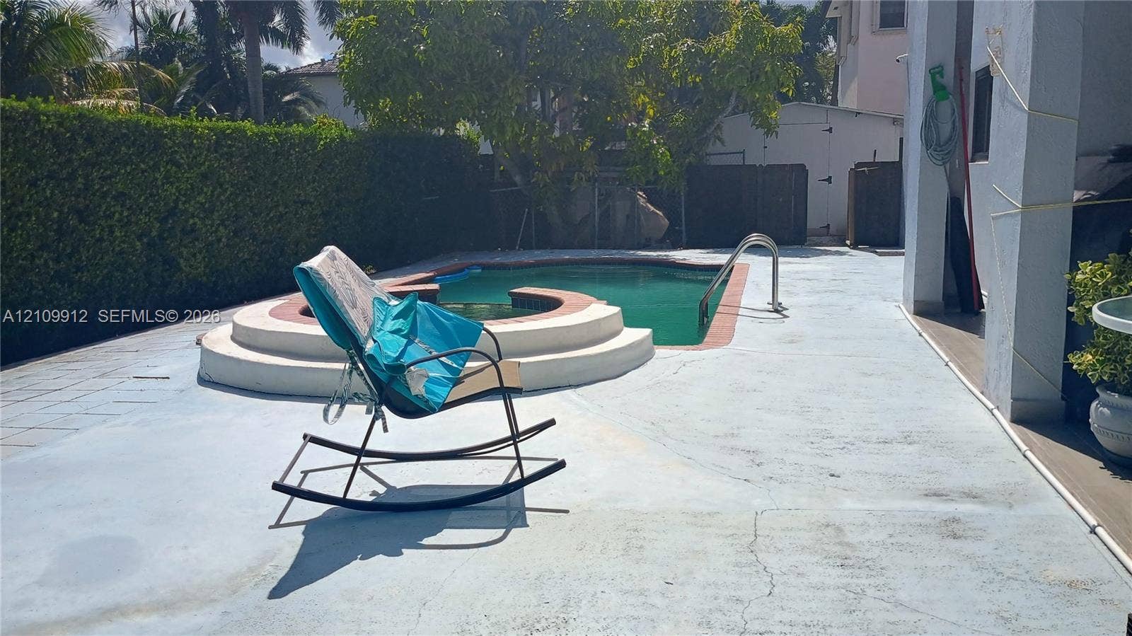 3253 SW 150 Court, Miami, FL 33185 Outdoor area featuring an in-ground swimming pool with an integrated spa, concrete patio, and mature perimeter hedging