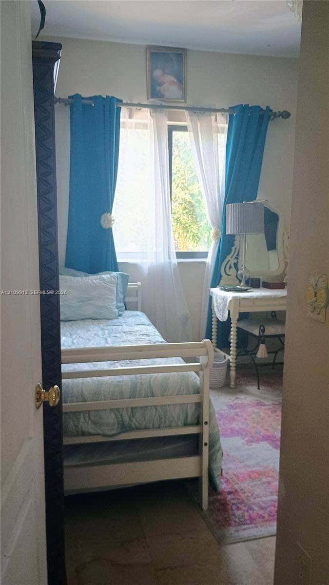 3253 SW 150 Court, Miami, FL 33185 Single window with horizontal blinds and a dark-finished door featuring decorative molding