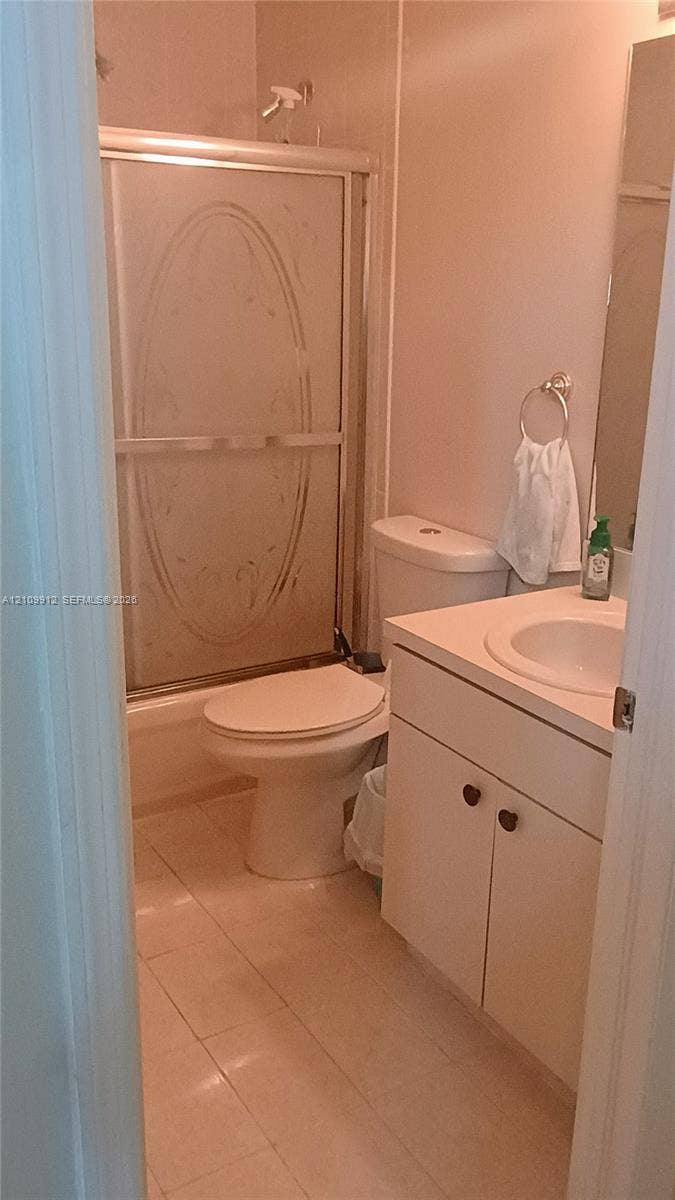 3253 SW 150 Court, Miami, FL 33185 Bathroom featuring a tub-shower combination with an etched glass sliding door, vanity cabinet with integrated sink, tiled flooring, and wall-mounted mirror