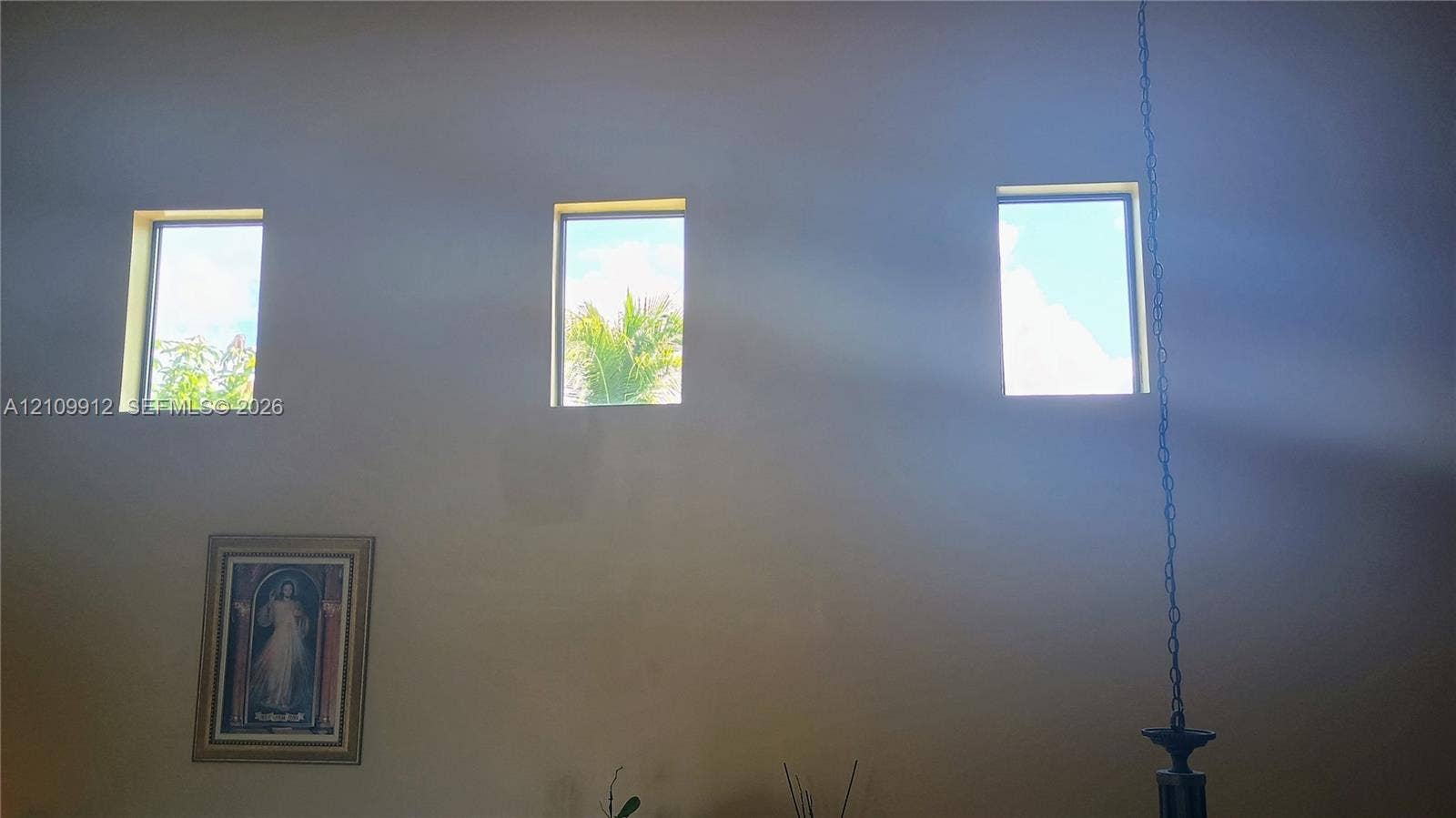 3253 SW 150 Court, Miami, FL 33185 High-reaching walls featuring three clerestory windows and a decorative hanging light fixture