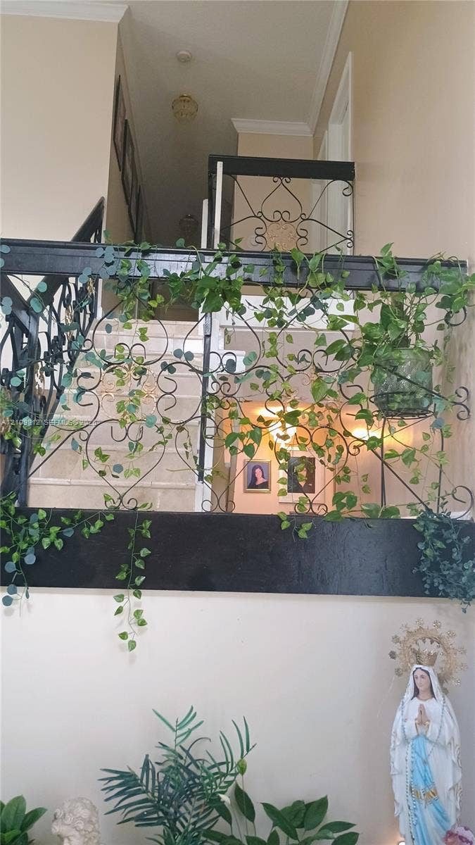 3253 SW 150 Court, Miami, FL 33185 Ornate decorative metal balustrade featuring intricate scrollwork and a dark finish, complemented by crown molding and high-ceiling architecture