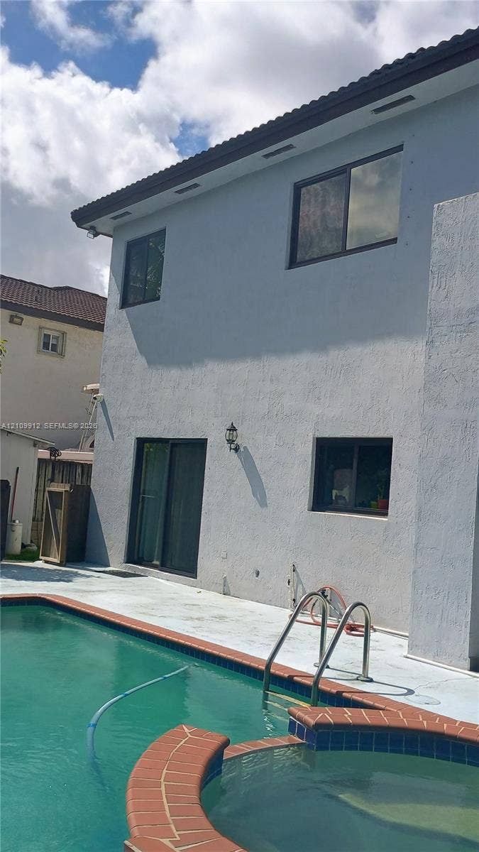 3253 SW 150 Court, Miami, FL 33185 Exterior featuring a two-story stucco facade, private swimming pool, integrated spa, and concrete pool deck
