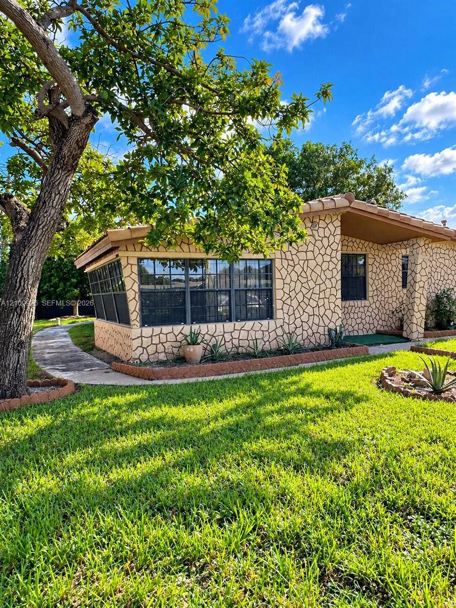 1440 NW 183rd Street, #0, Miami Gardens, Miami Gardens, FL 33169 Exterior featuring stone veneer siding, concrete walkway, multi-pane windows, and tile roofing
