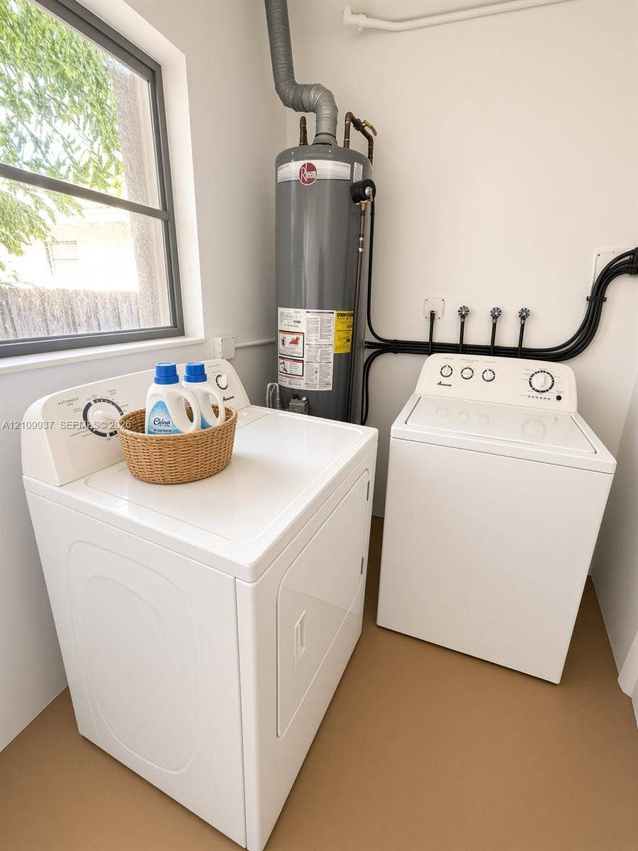 1024 Tyler Street, #2, Hollywood, Hollywood, FL 33019 Dedicated utility space featuring a vertical water heater and dedicated appliance hookups, complemented by natural light from a window