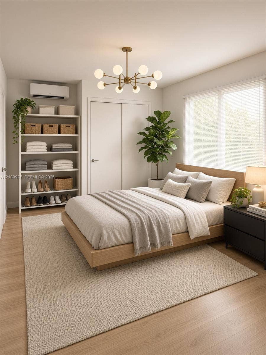 1024 Tyler Street, #2, Hollywood, Hollywood, FL 33019 Multi-arm brass globe chandelier, wood-finish flooring, wall-mounted climate control unit, and window with blinds