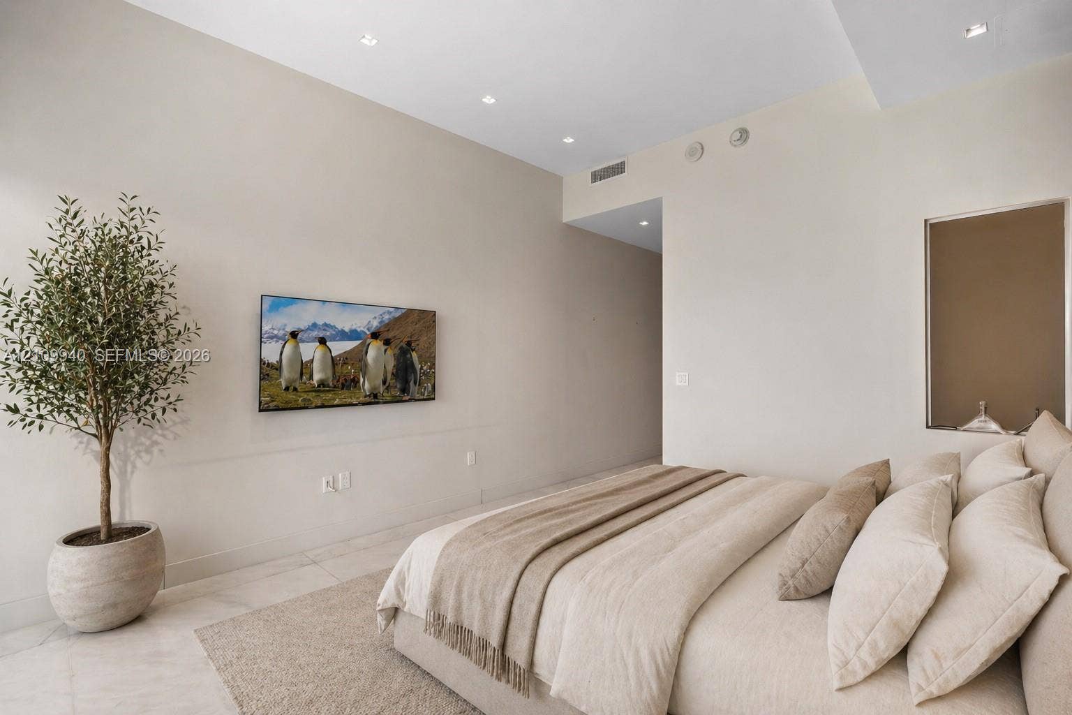 Neutral-toned interior space featuring recessed ceiling lighting, light-colored tile flooring, and a recessed wall niche