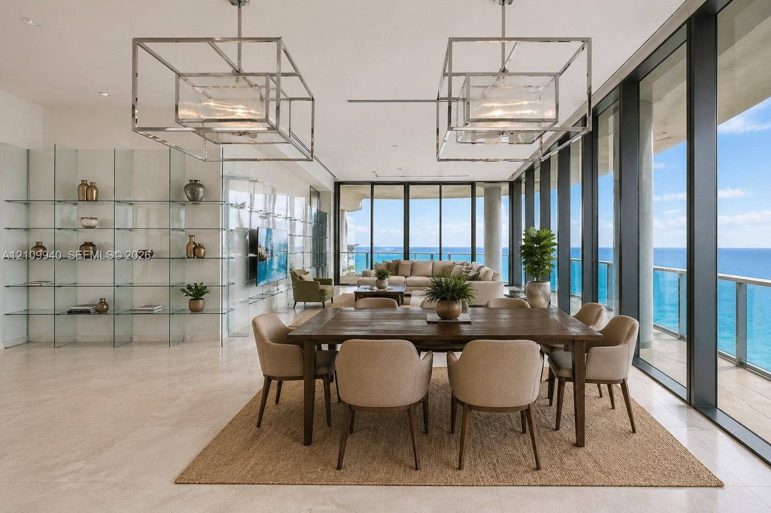 Open-concept living space featuring floor-to-ceiling glass walls, polished stone flooring, custom integrated glass shelving, and dual geometric-frame pendant light fixtures