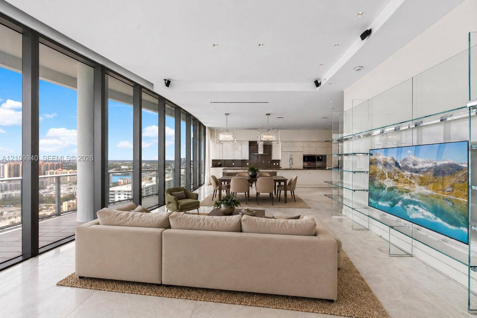 Floor-to-ceiling glass walls, integrated wall-mounted glass display shelving, recessed ceiling lighting, light-toned stone-finish flooring, and expansive open-plan layout