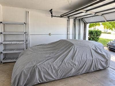 8528 Windsor Drive, Miramar, FL 33025 Enclosed garage space featuring a concrete floor, painted walls, and an overhead door track system