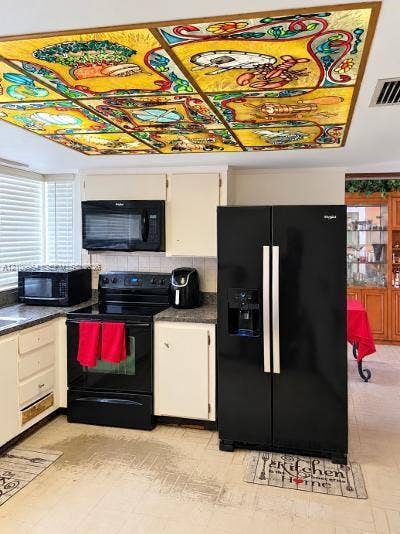 8528 Windsor Drive, Miramar, FL 33025 Custom multi-panel stained glass ceiling feature, black finish side-by-side refrigerator, matching black range with integrated microwave, and white cabinetry