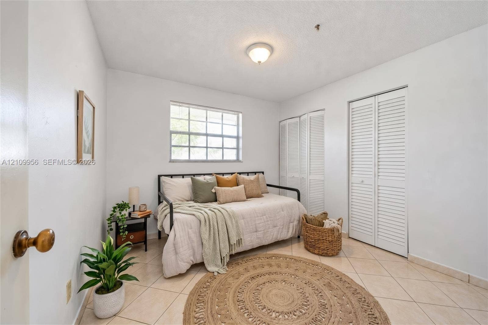 19503 SW 114th Place, Miami, FL 33157 Interior space featuring neutral wall tones, ceramic tile flooring, a multi-pane window, and dual closets with louvered doors