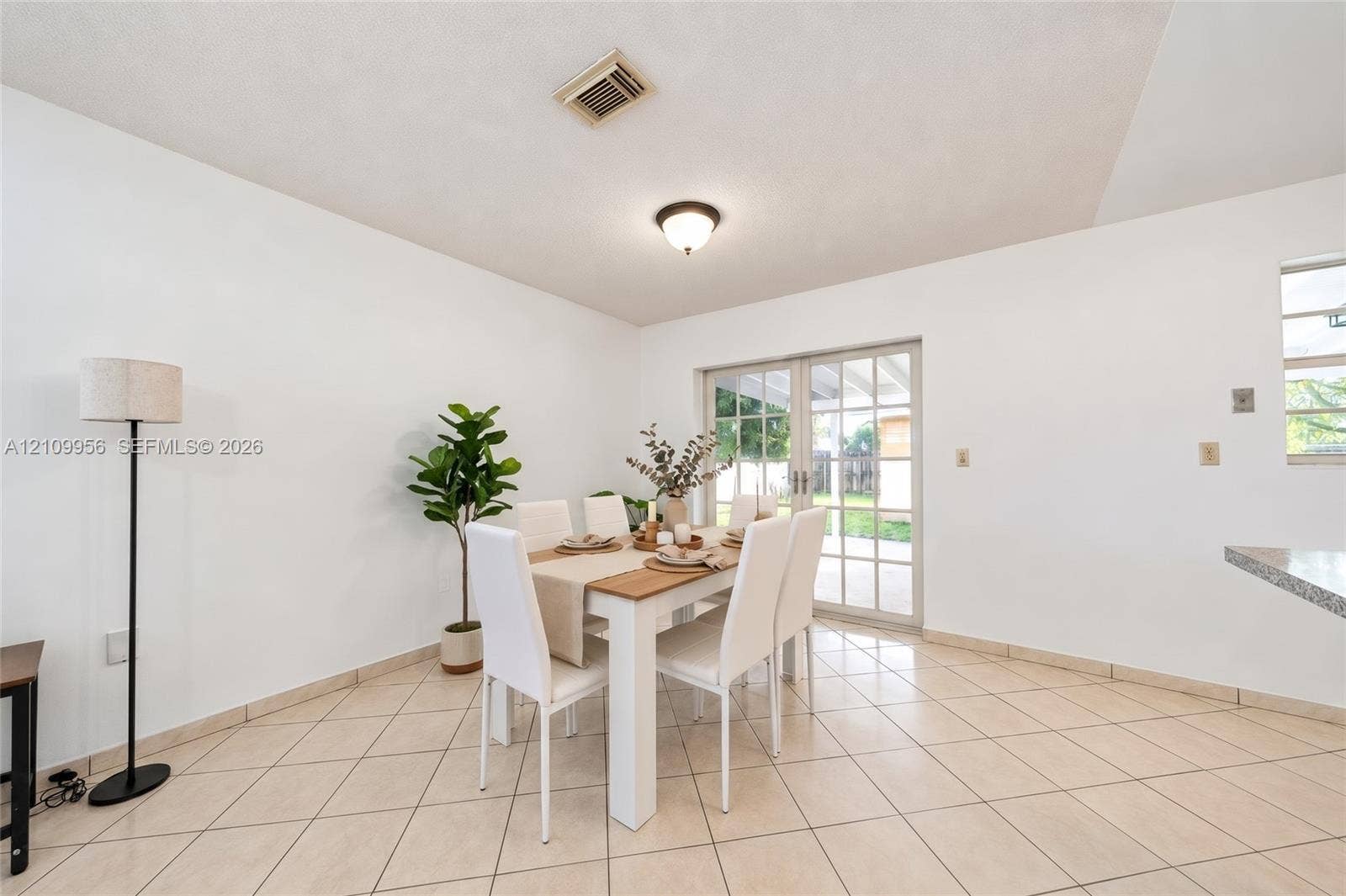 19503 SW 114th Place, Miami, FL 33157 Neutral-toned ceramic tile flooring, dual-panel glass sliding doors with white frames, and flush-mount ceiling lighting